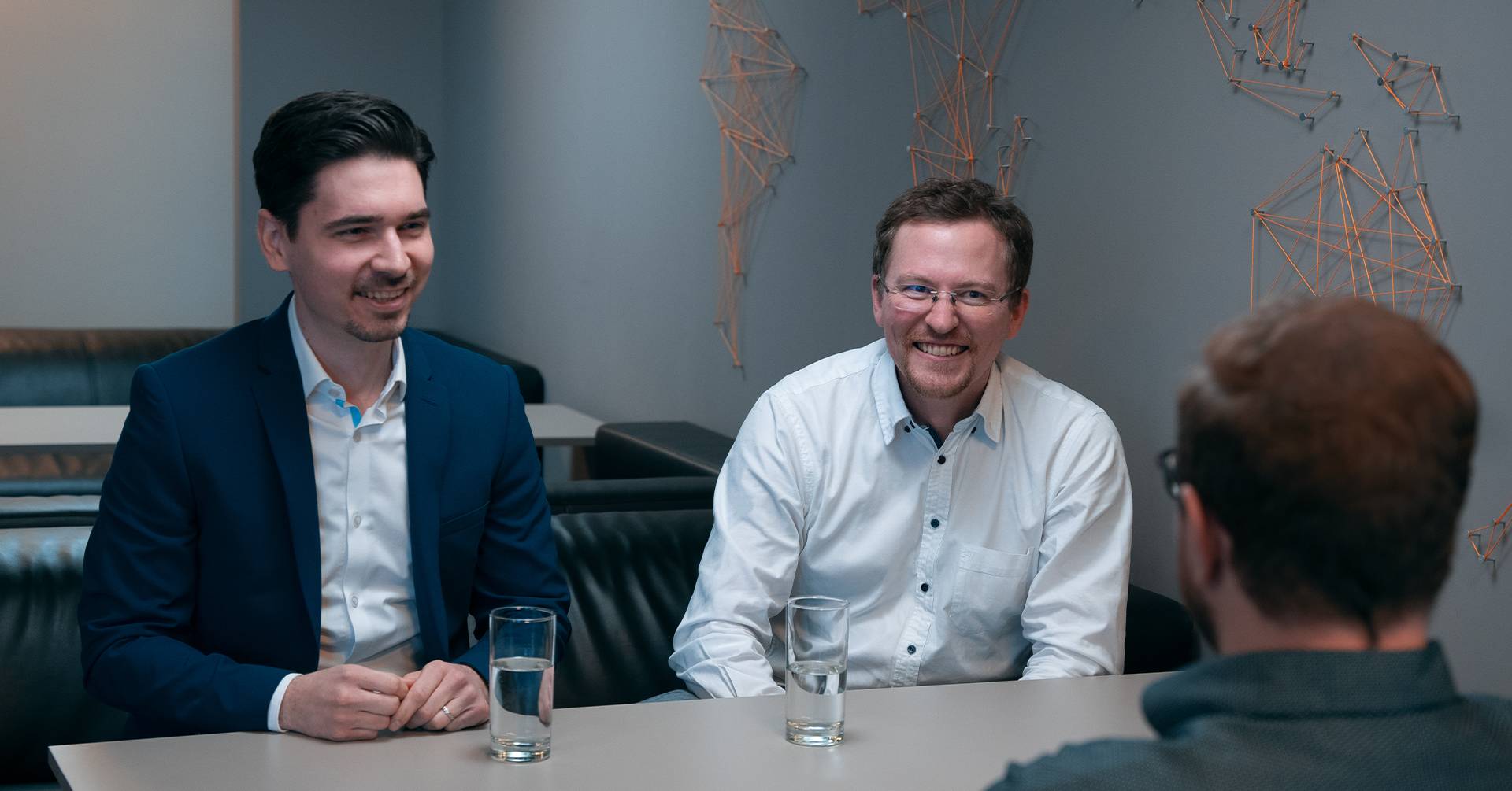 Three men sitting at the table, talking and smiling
