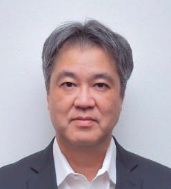 暗いスーツジャケットを着た中年男性、落合則和の写真。