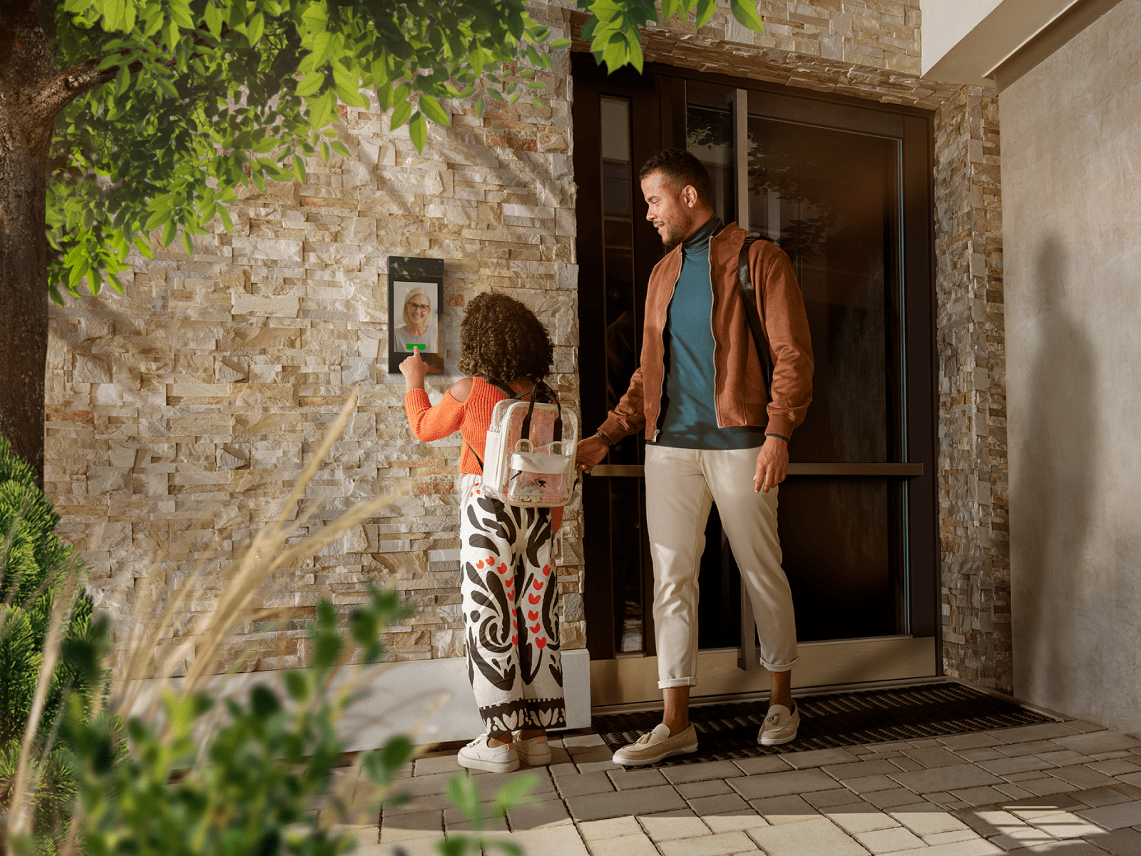 Un père et sa fille rentrent à la maison, et la fille utilise un clavier à côté de la porte.