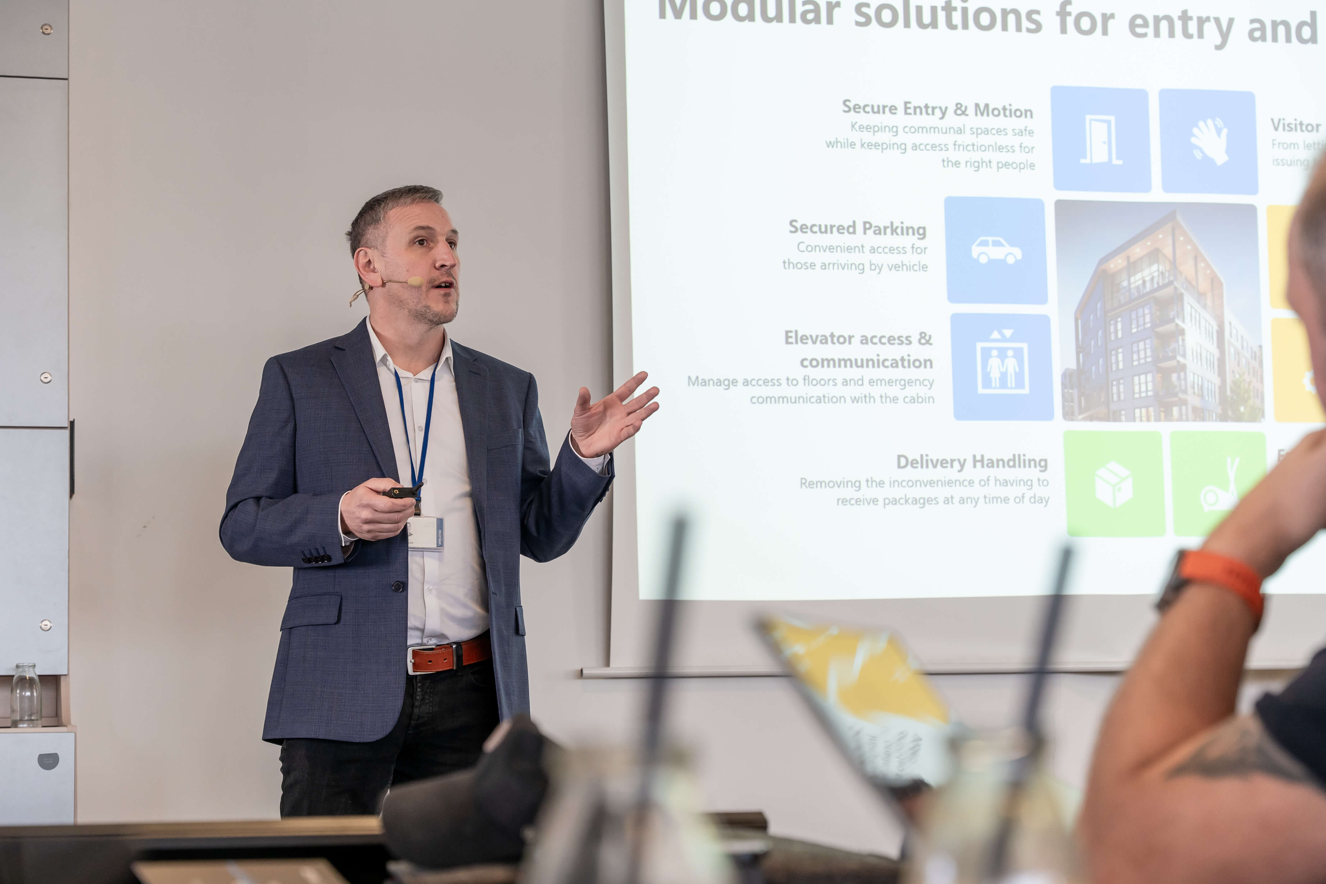 A presenter discusses "Modular solutions for entry and access" using a presentation slide with icons.