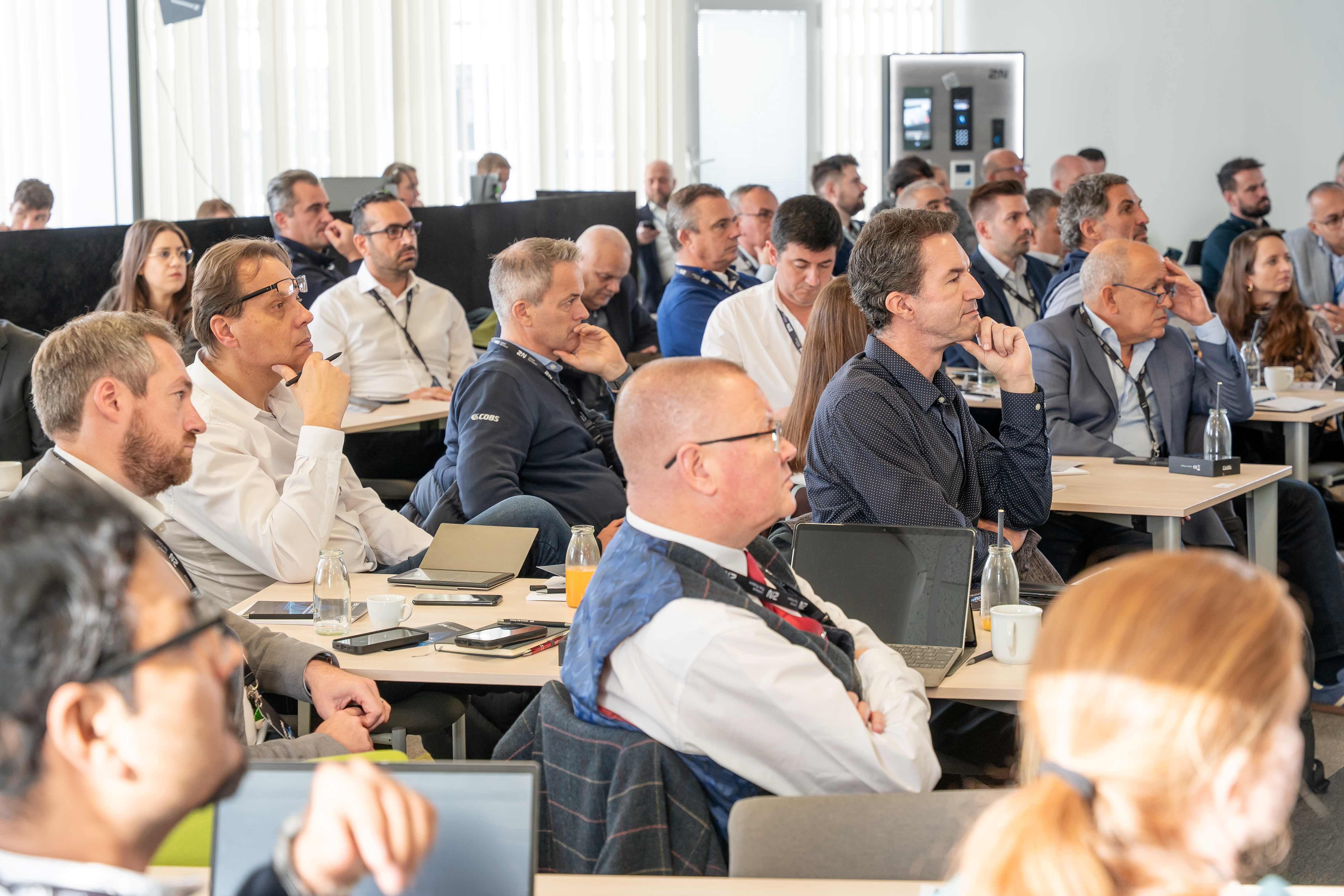 A room full of professional men and women attending a focused business seminar or conference.