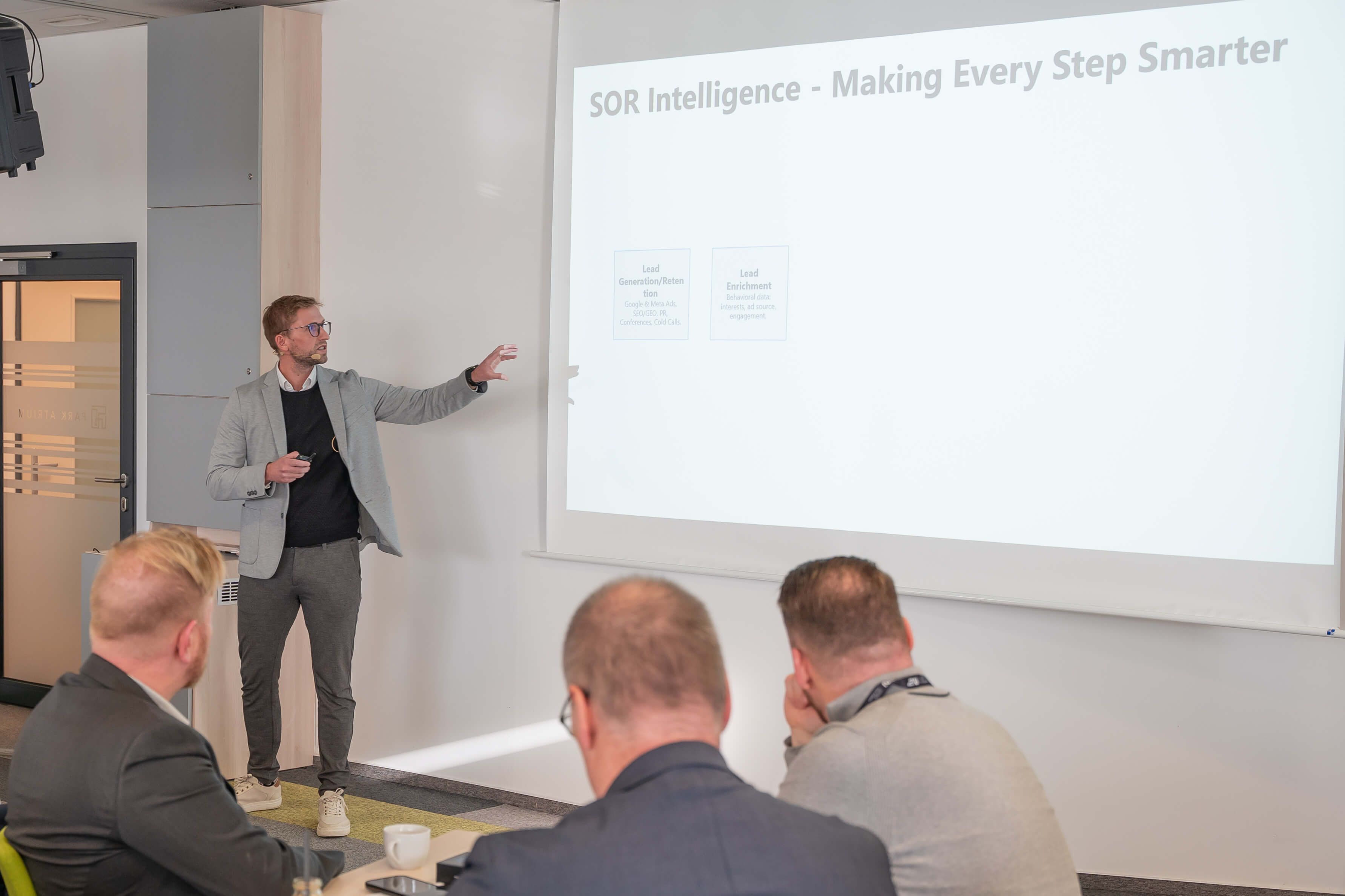 A presenter discusses "SDI Intelligence - Making Every Step Smarter" to an attentive audience.