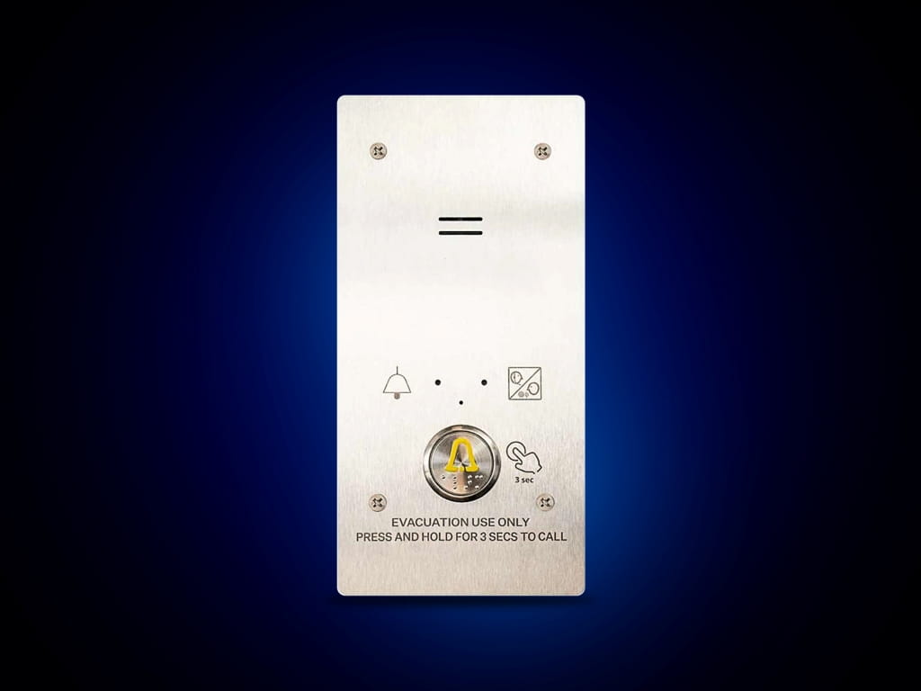 A brushed metal elevator emergency call panel facing front with a prominent yellow and black alarm icon.