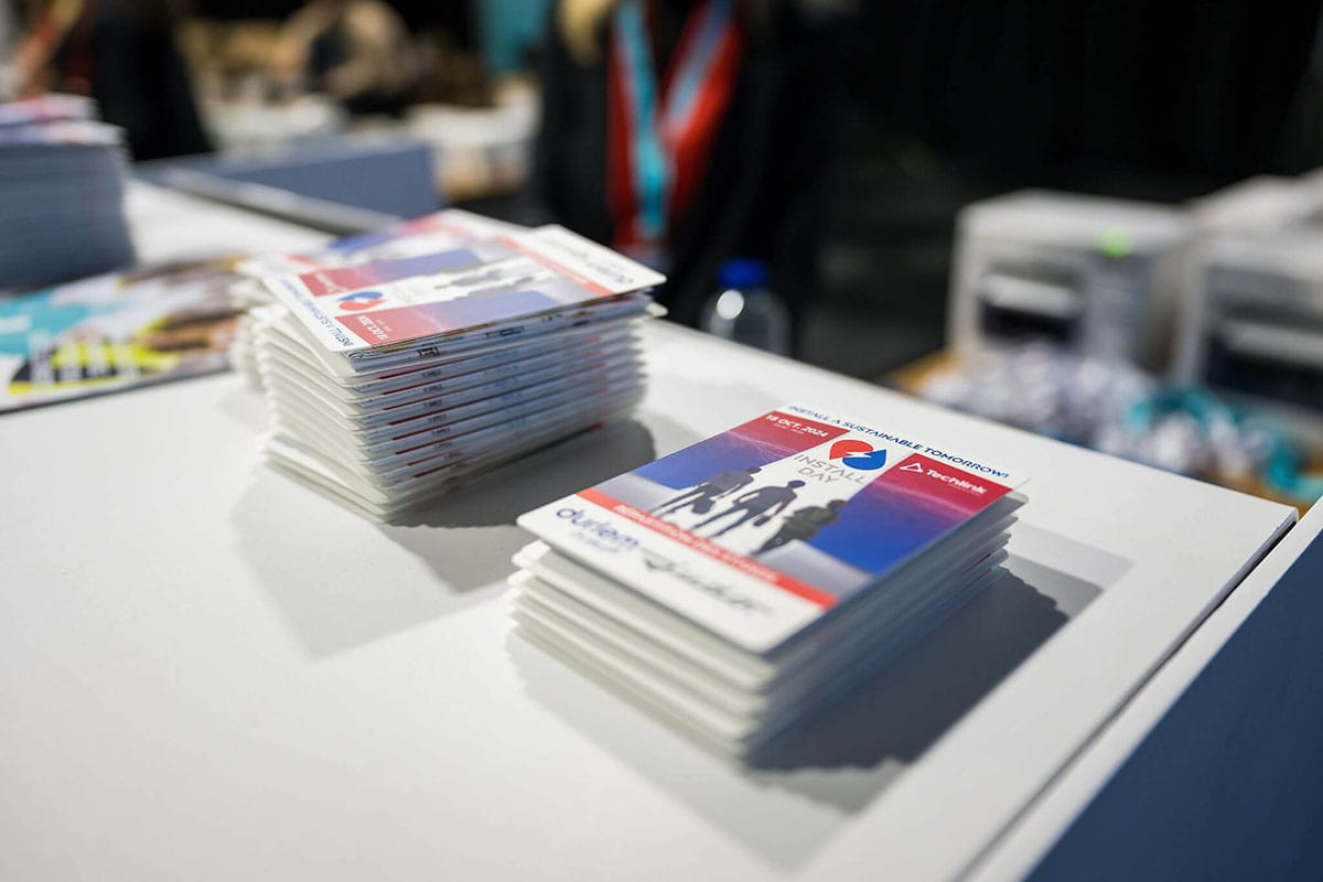 Stacks of event badges with Czechia branding and a horse image placed on a white counter.