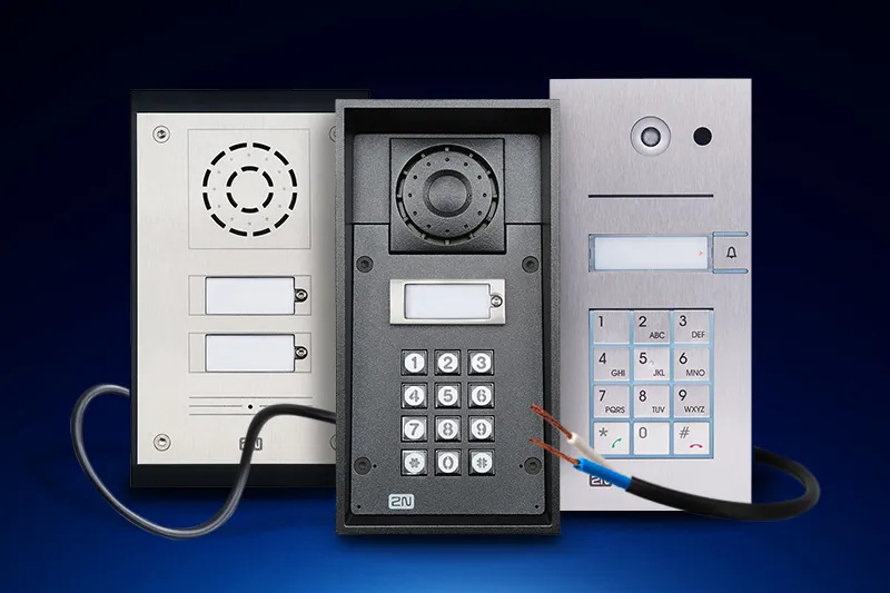 Three intercom panels with keypads and a camera module displayed against a dark blue background.