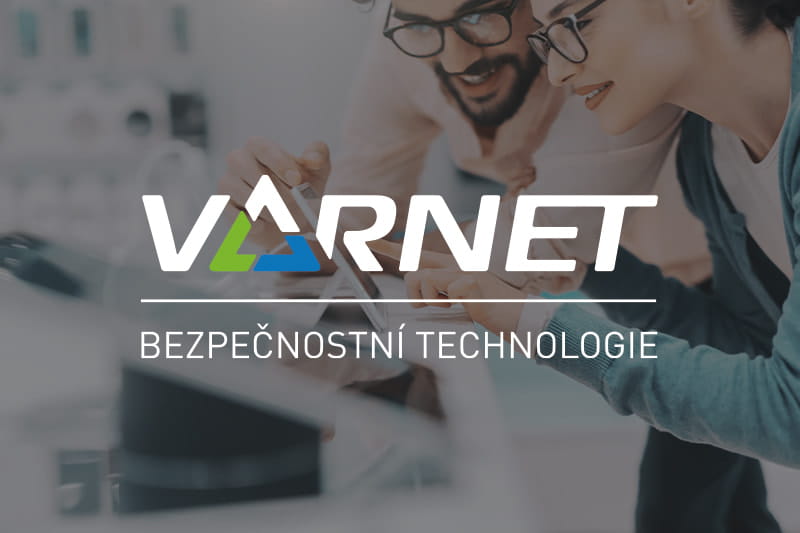 Logo VARnet s textem „Bezpečnostní technologie“ na rozostřeném pozadí lidí, kteří se dívají na technologická zařízení.
