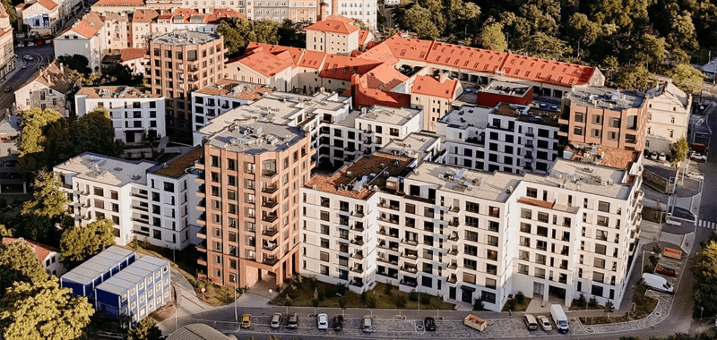 Fotografía aérea de un complejo residencial moderno con varios edificios de apartamentos de varias plantas y calles circundantes.