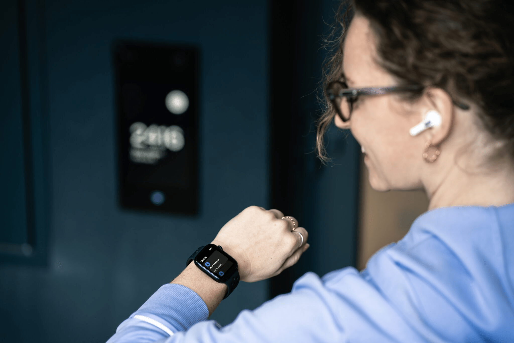 Person using the My2N app on an Apple Watch to interact with a 2N door intercom.