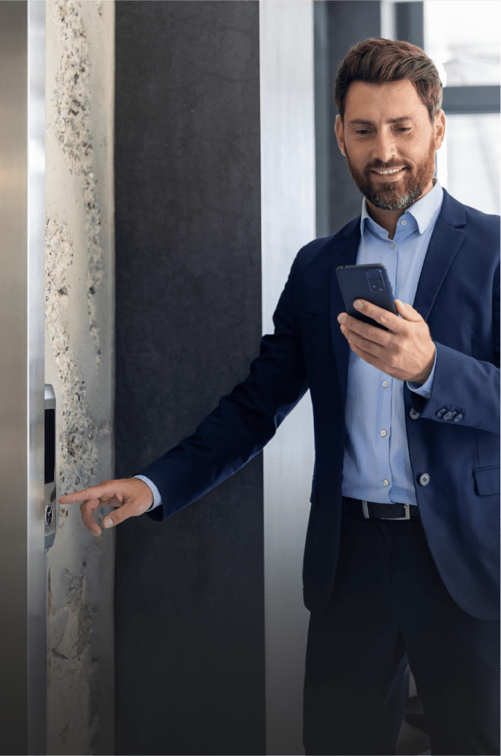 Homme appelant l'ascenseur et regardant son téléphone