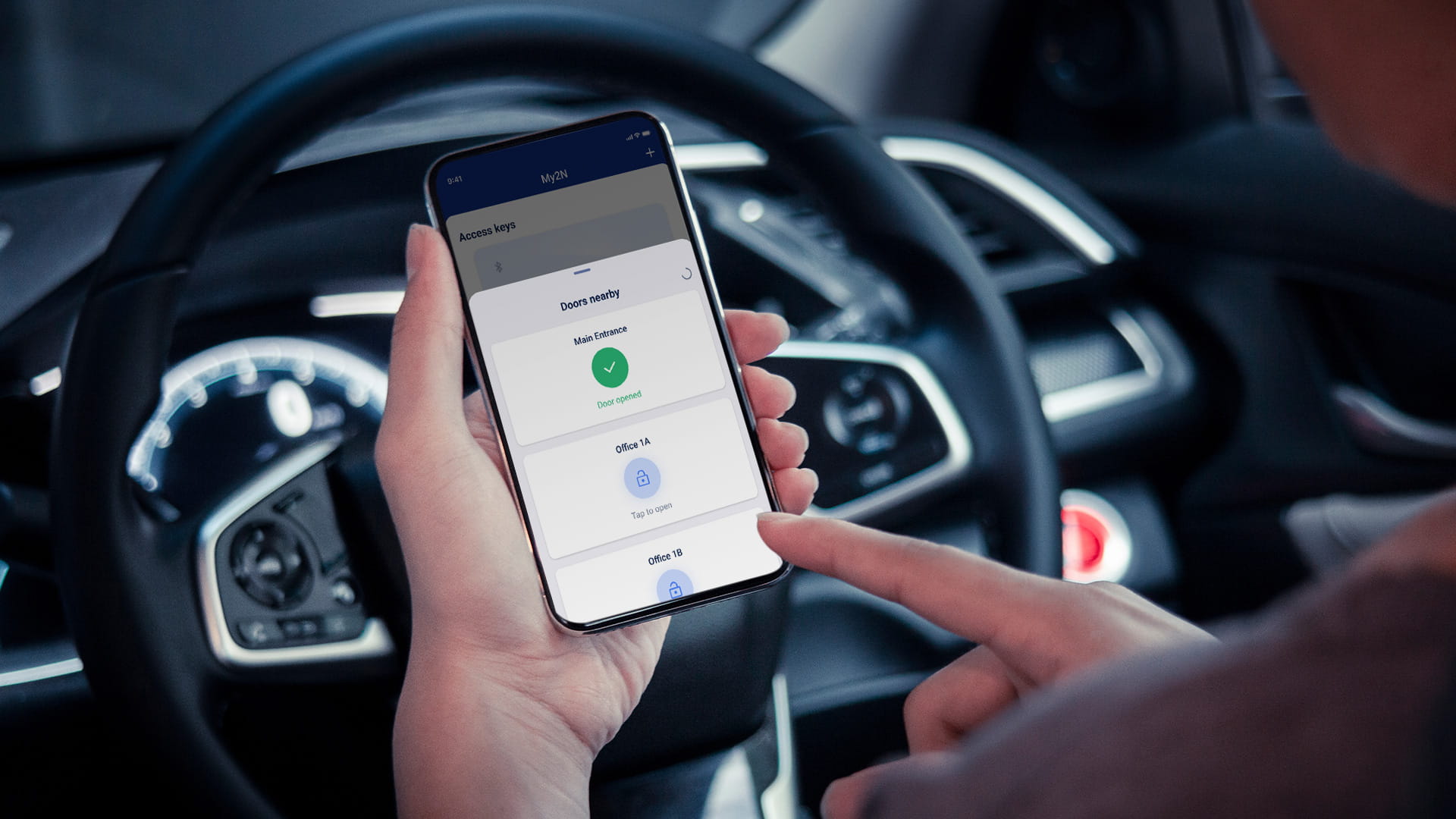 車内にいる人物がスマートフォンアプリを使って、接続された機器を操作したり監視したりしている。