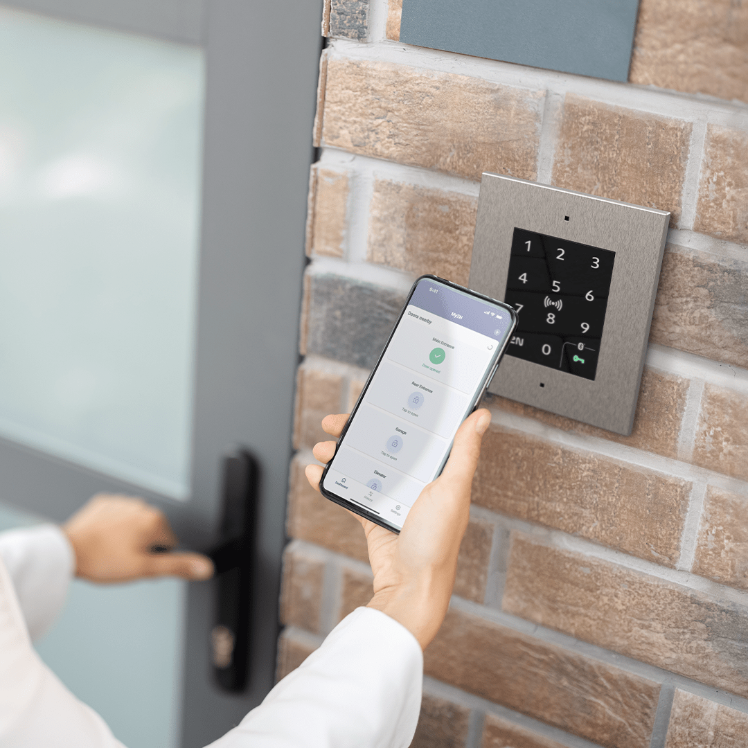 Iemand die Access Unit 2.0 met een smartphone gebruikt om de deur te openen