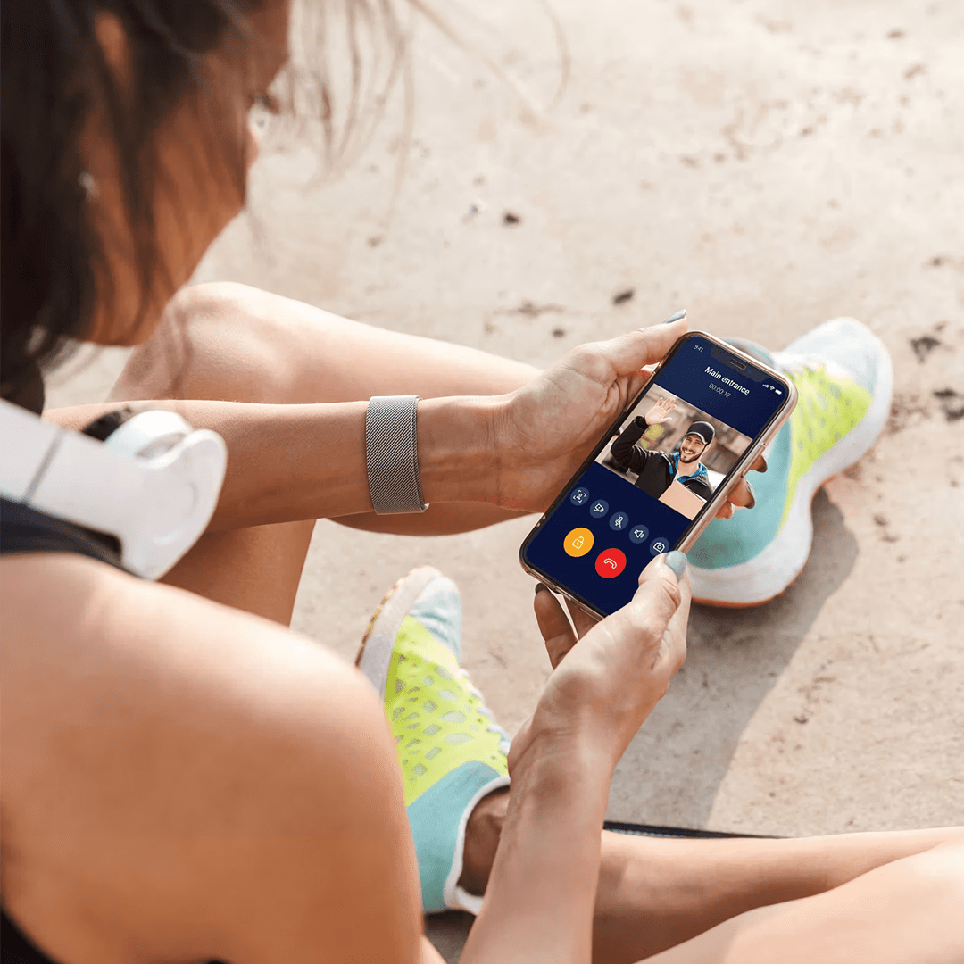 Vrouw die een mobiele app gebruikt voor een videogesprek via de intercom