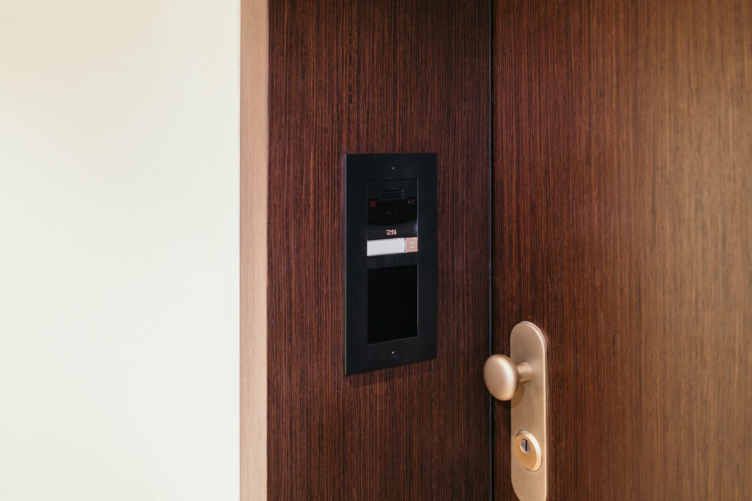 Interphone de porte 2N Verso 2.0 installé sur une porte en bois pour un contrôle d'accès sécurisé.