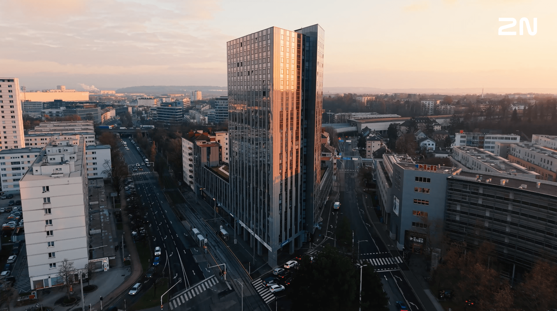 Luchtfoto van een hoog modern gebouw in Linz met de tekst 'High Five' en 'Linz, Oostenrijk' erop.