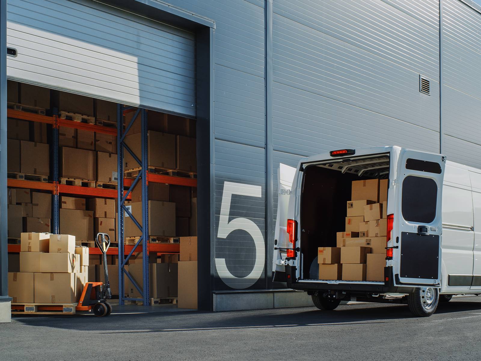Delivery van being loaded with boxes at a warehouse loading bay