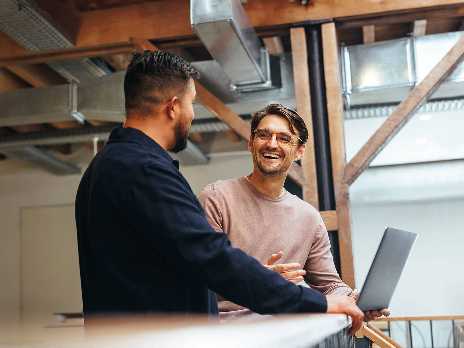 Twee collega's die een project bespreken met een laptop in een modern kantoor