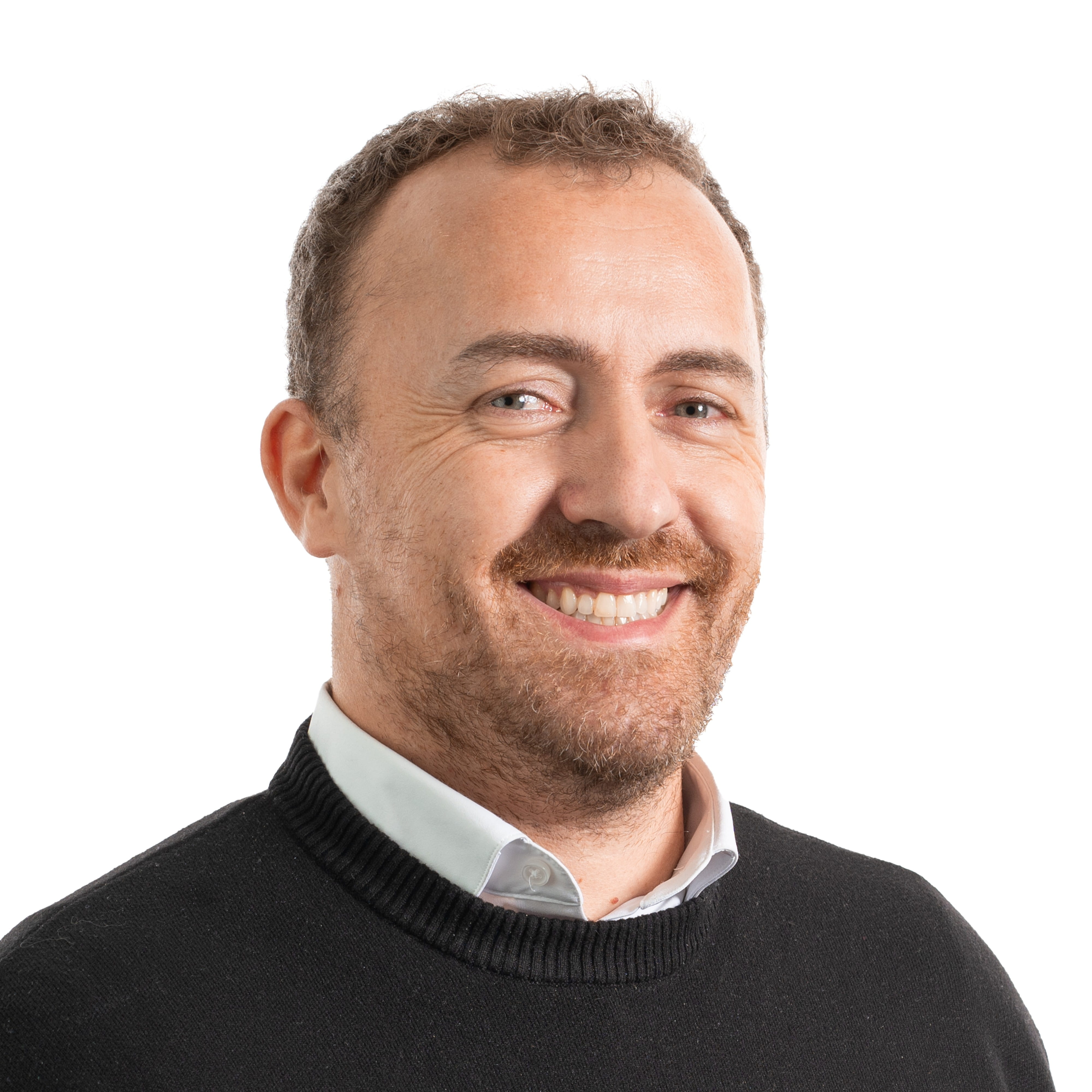 Portrait of a person wearing a dark sweater over a collared shirt against a plain light gray background.